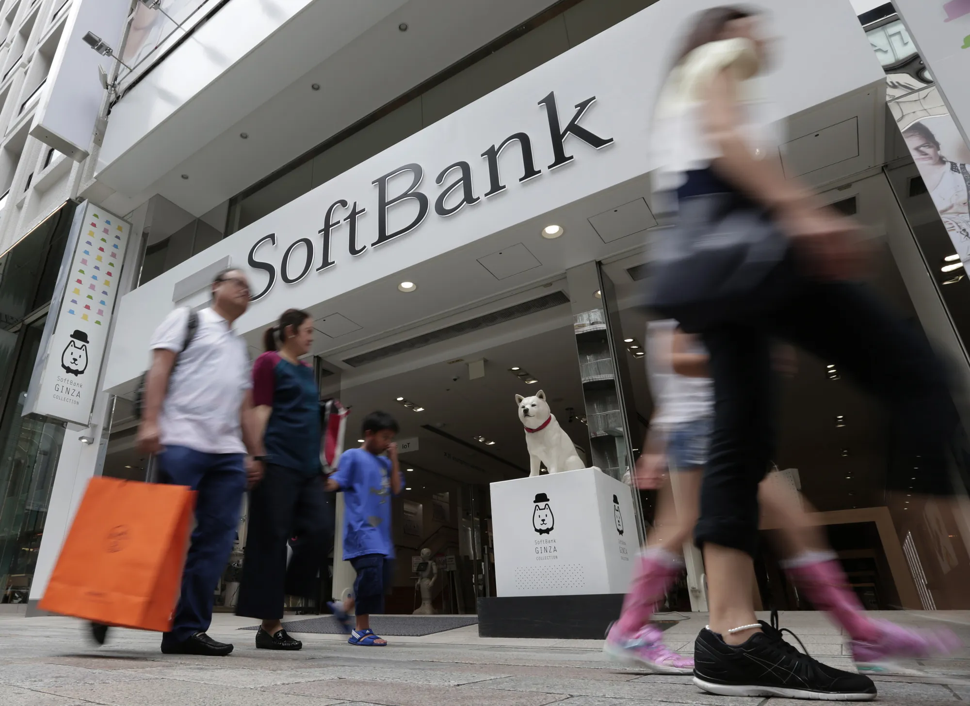 Pedestrians walk by a SoftBank Group Corp. store in Tokyo.