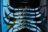 Fiber optic cables, center, and copper Ethernet cables feed into switches inside a communications room at an office in London, U.K., on Monday, May 21, 2018. The Department of Culture, Media and Sport will work with the Home Office to publish a white paper later this year setting out legislation, according to a statement, which will also seek to force tech giants to reveal how they target abusive and illegal online material posted by users.