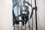 A bitcoin logo sits on a security gate inside the offices of La Maison du Bitcoin bank.