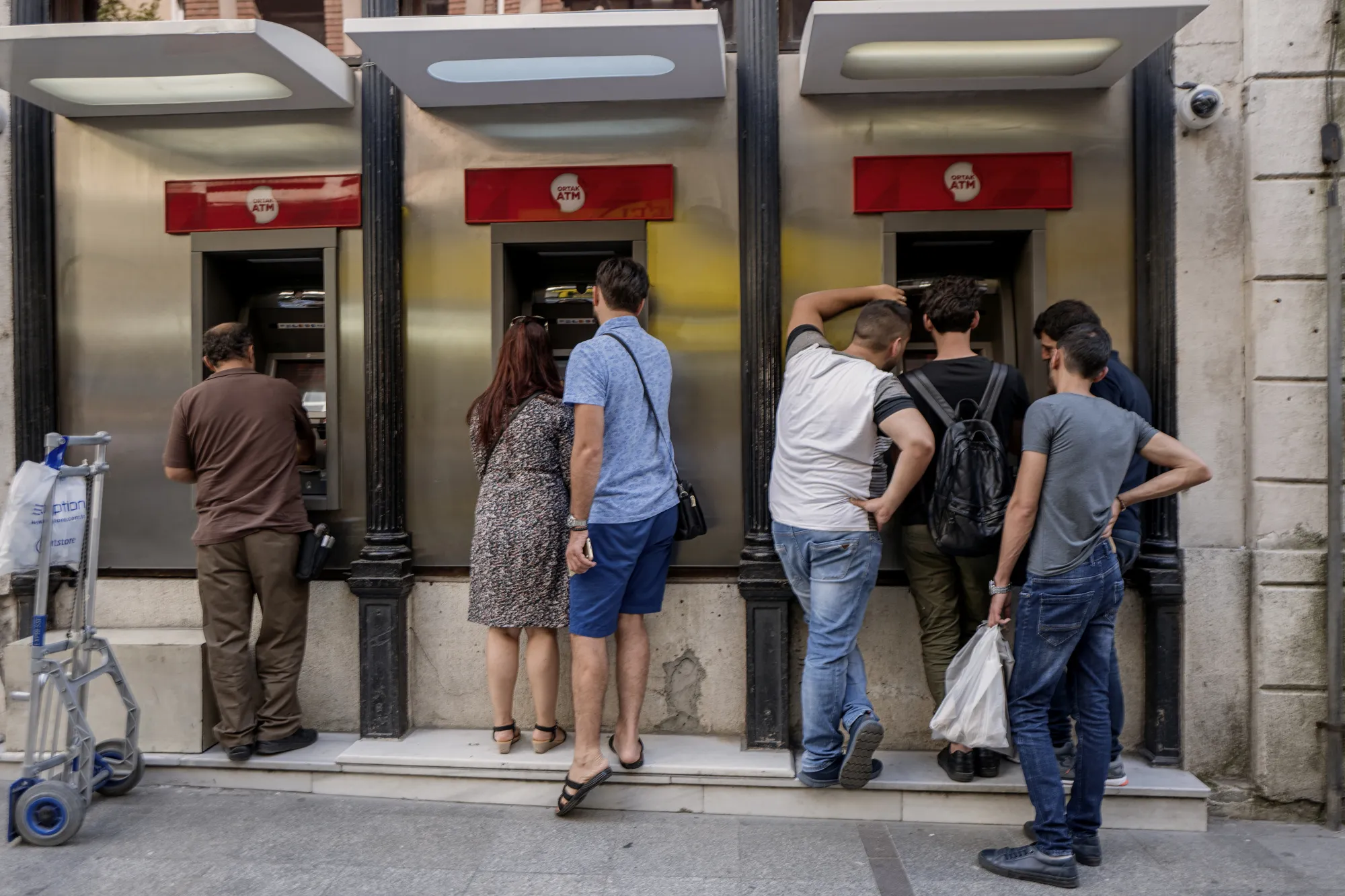 Customers use automated teller machines (ATM) on a street in Istanbul.