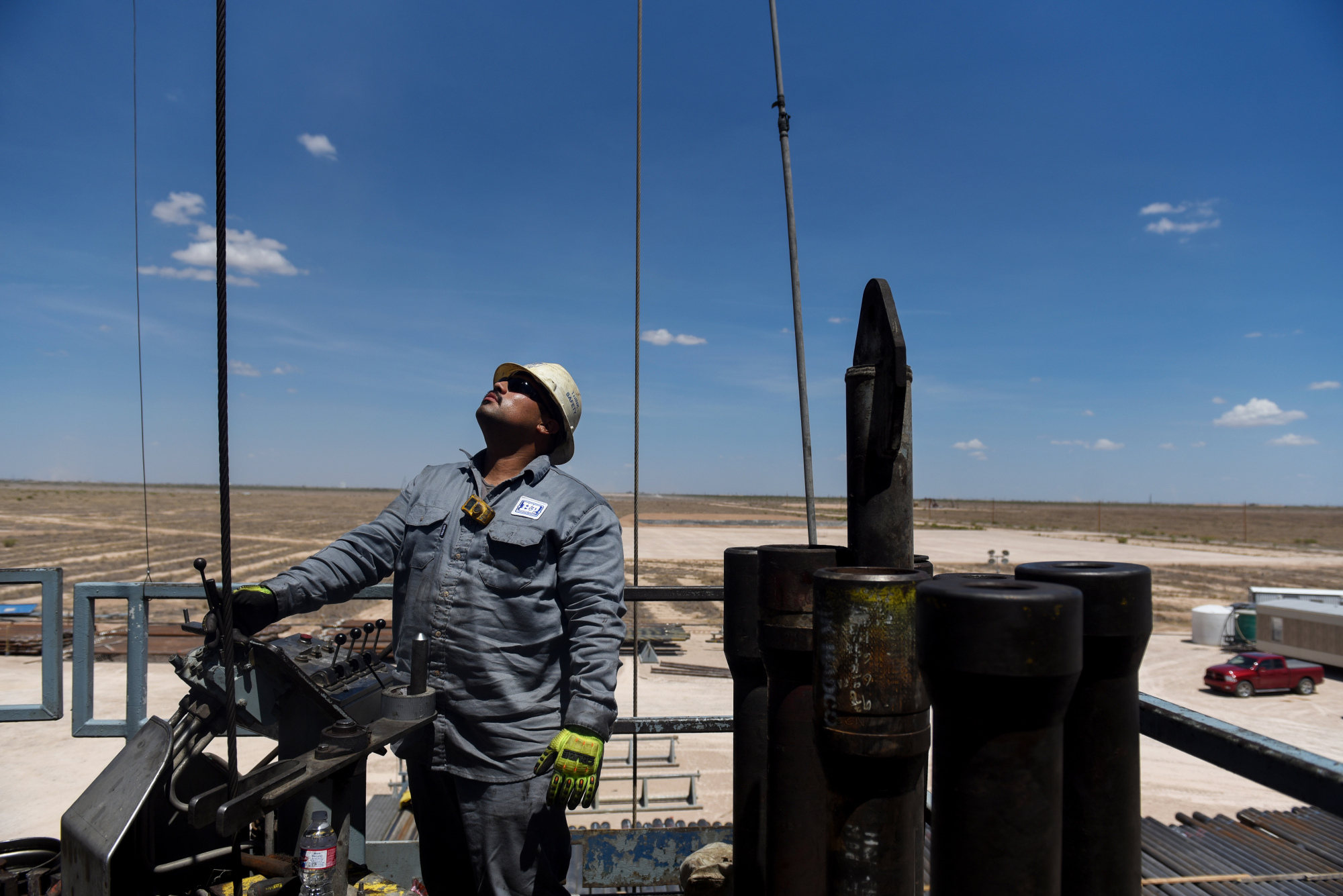 A contractor maneuvers drilling pipe at an oil rig in Reeves County, Texas.