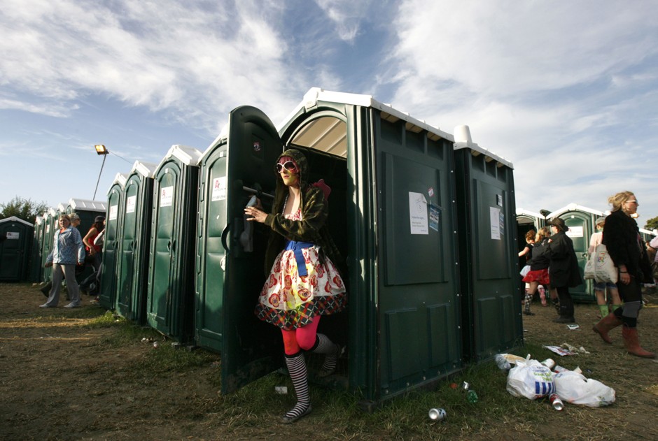 A festival-goer exits a porta potty at Somerset, England's famous Glastonbury Festival in 2008.