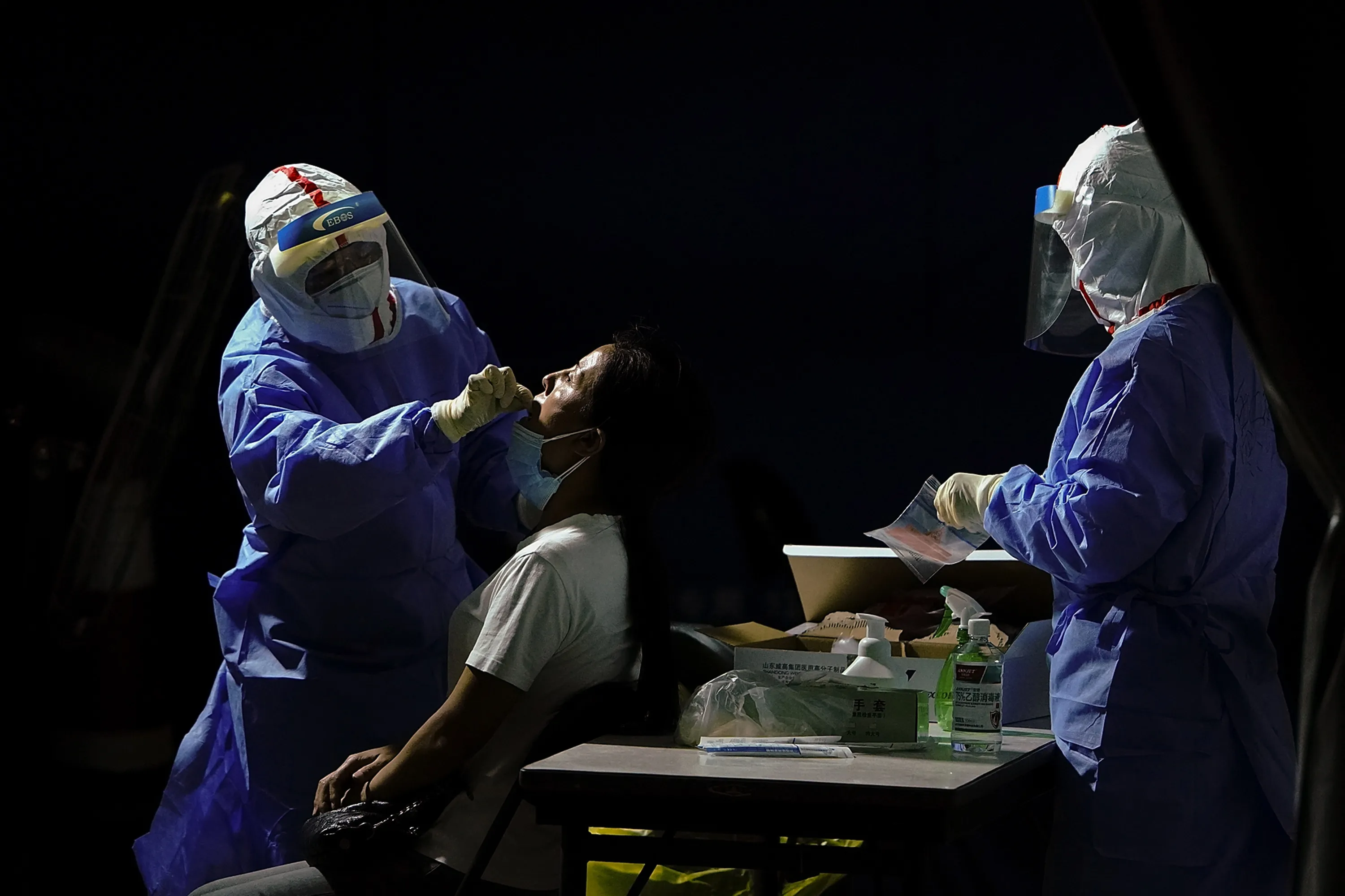 A nurse tests a person who either visited or lives near the Xinfadi Market, at a testing facility in Beijing on June 17.