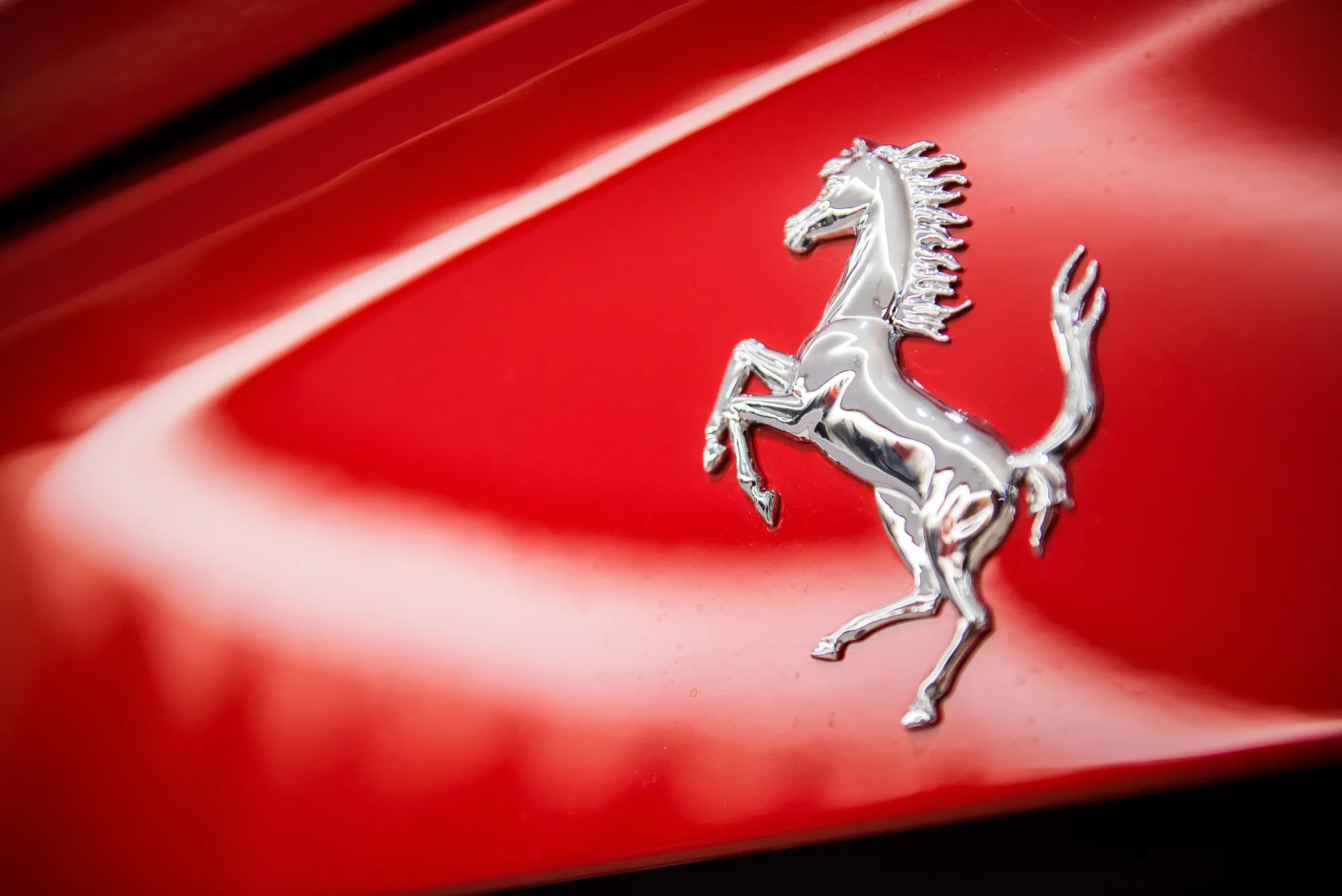 Ferrari’s prancing horse logo sits on the bodywork of Ferrari F12 Berlinetta luxury automobile.