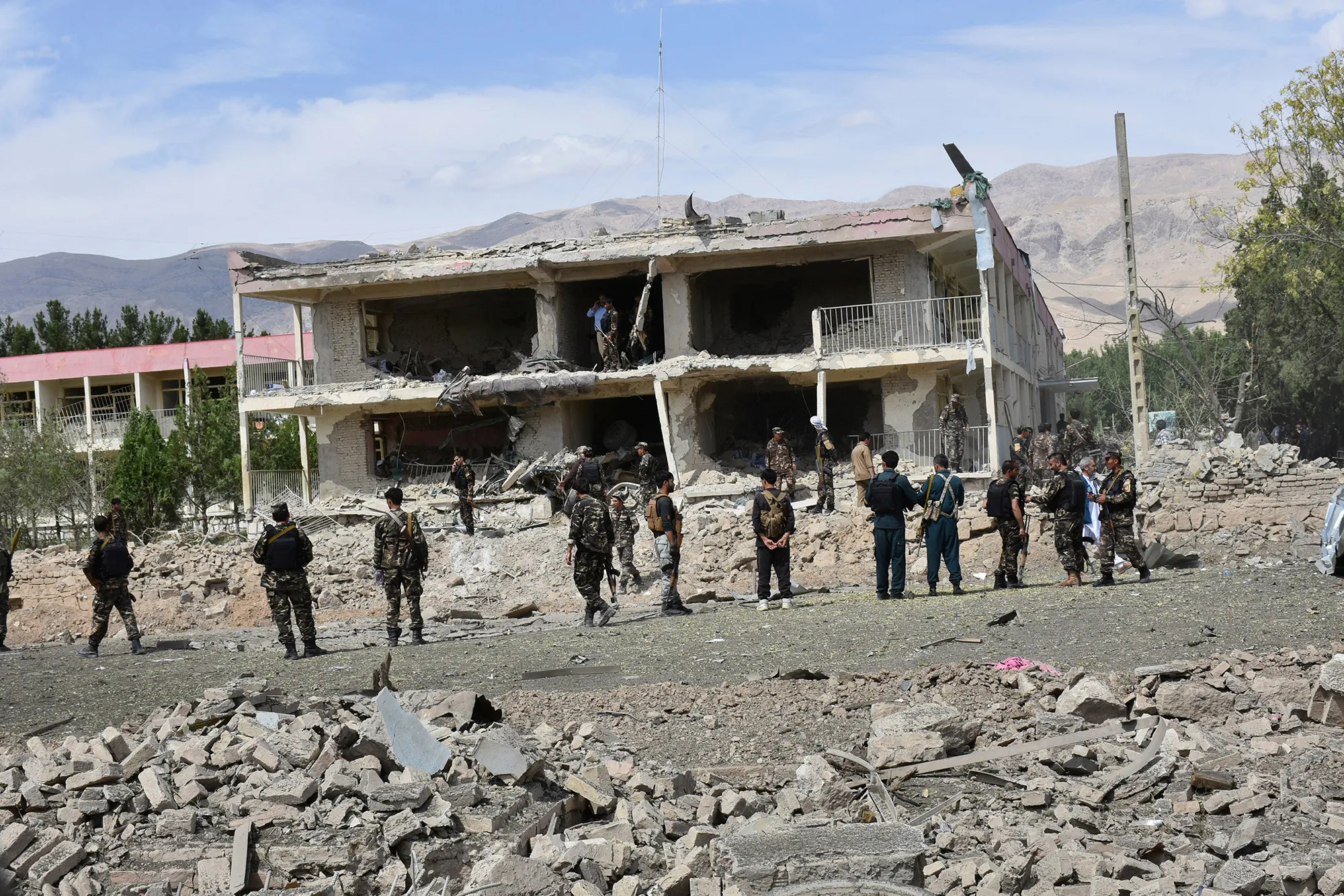 Afghan security forces inspect the site of a car bomb blast in Aybak, northern Afghanistan in July.