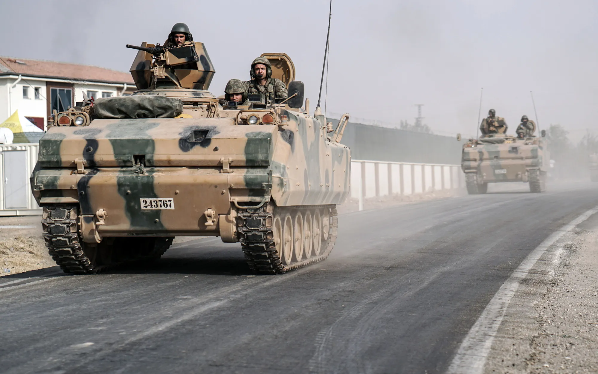 Turkish army tanks and armored personnel carriers move toward the Syrian border, in Karkamis, Turkey, on Aug. 25, 2016.
