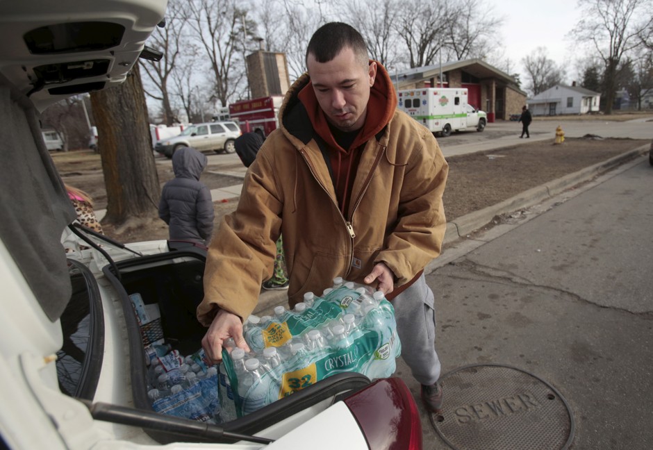 Flint resident Jerry Adkisson loads bottled water, which he picked up from a fire station, into his car in Flint, Michigan.