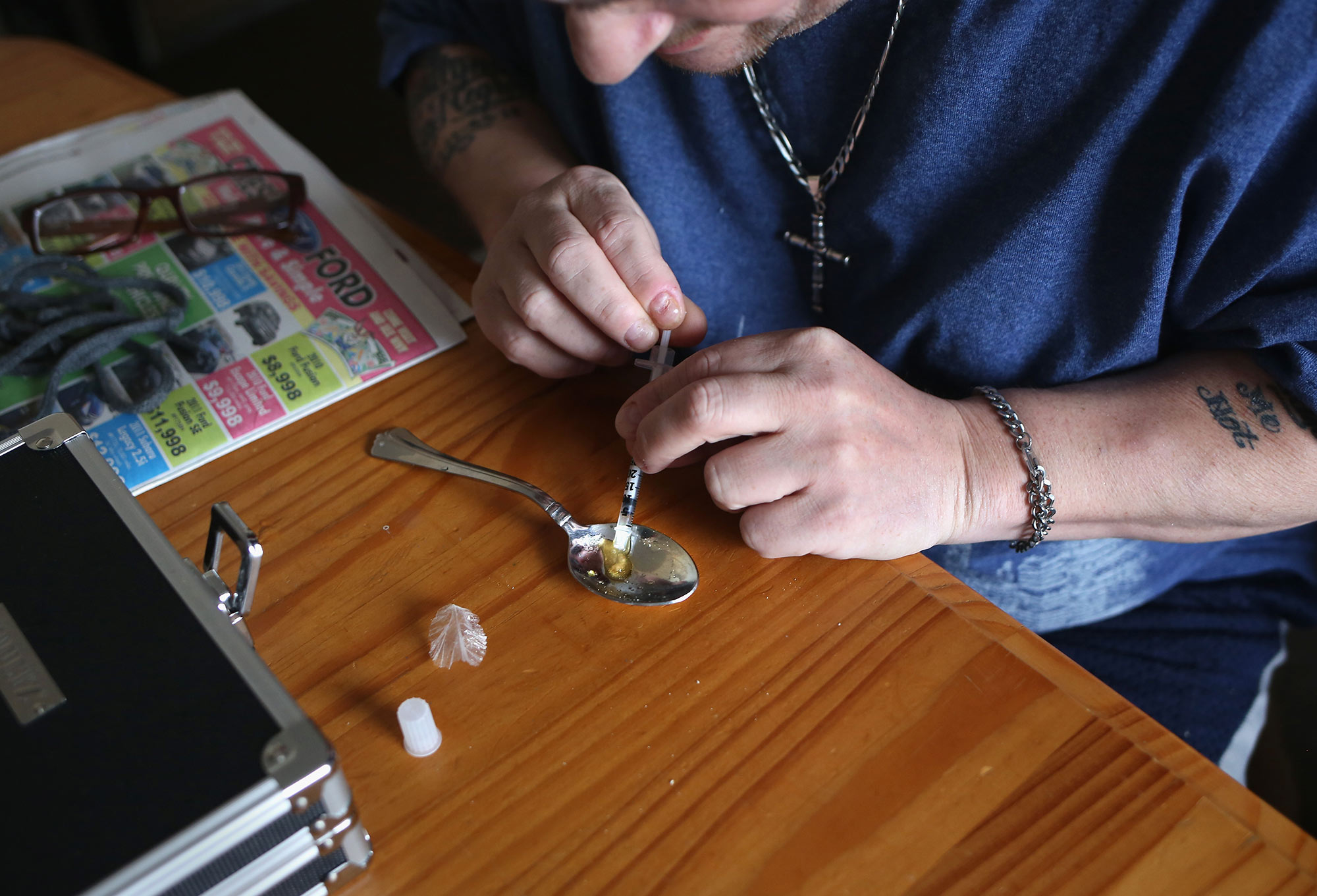 A heroin user prepares to inject himself on March 23, 2016 in New London, Conn.
