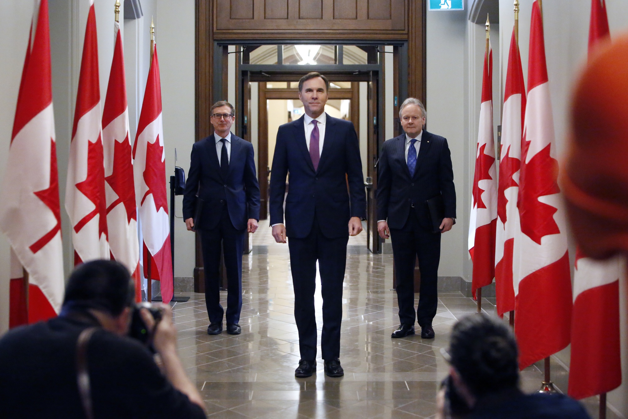 Bill Morneau, center, Stephen Poloz, right, and Tiff Macklem arrive for a press conference on Parliament Hill in Ottawa, May 1.