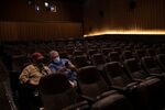 Guests wearing protective masks sit before an afternoon movie at a theater in Bloomfield Township, Michigan on Oct. 9.