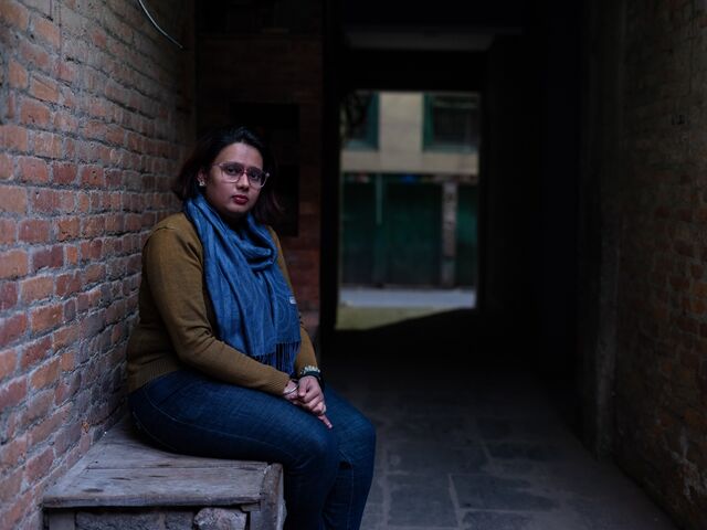 Амрита Бан, 23-летняя студентка, сидит на скамейке в Лалитпуре, Непал.