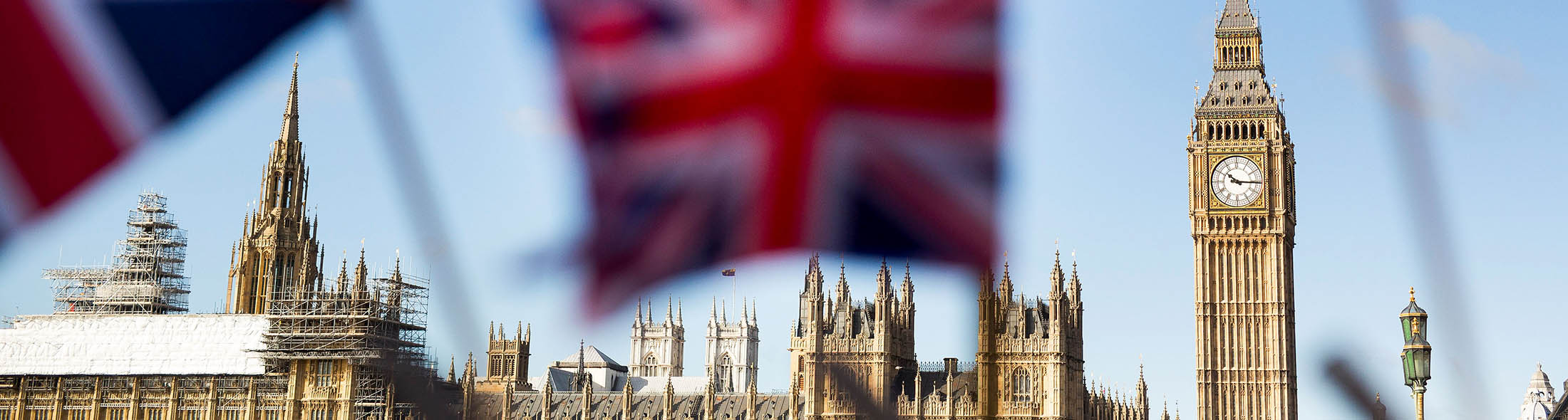 A display of U.K., Union Jack flags fly in front of The Houses of Parliament, in London, U.K., on Monday, Feb. 15, 2016. U.K. lawmakers are not the only ones bracing for a tough few months before Britain's referendum on its European Union membership. A gauge of expected volatility for the pound near the highest since 2011 shows traders are expecting a rough ride too.
