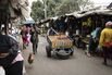 A worker pushes a cart past market shacks in Nairobi, Kenya.