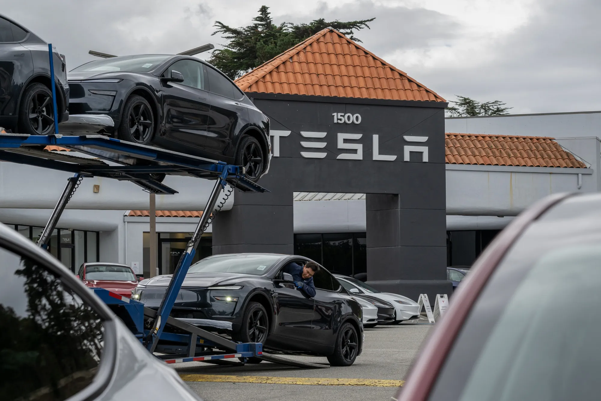 テスラの店舗でモデルYを輸送トラックから移動させるドライバー（米カリフォルニア州コルマ）
