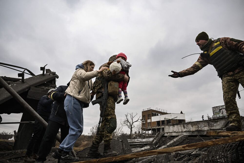 Ukrainian servicemen help evacuees from the city of Irpin, northwest of Kyiv.