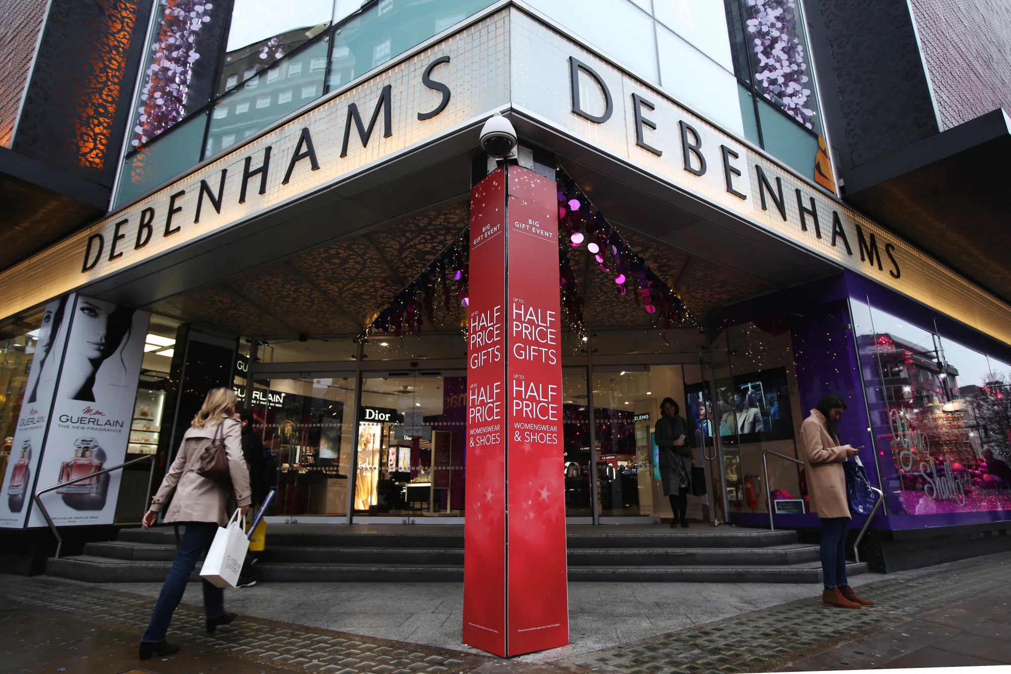 Shoppers enter a Debenhams Plc department store in London.