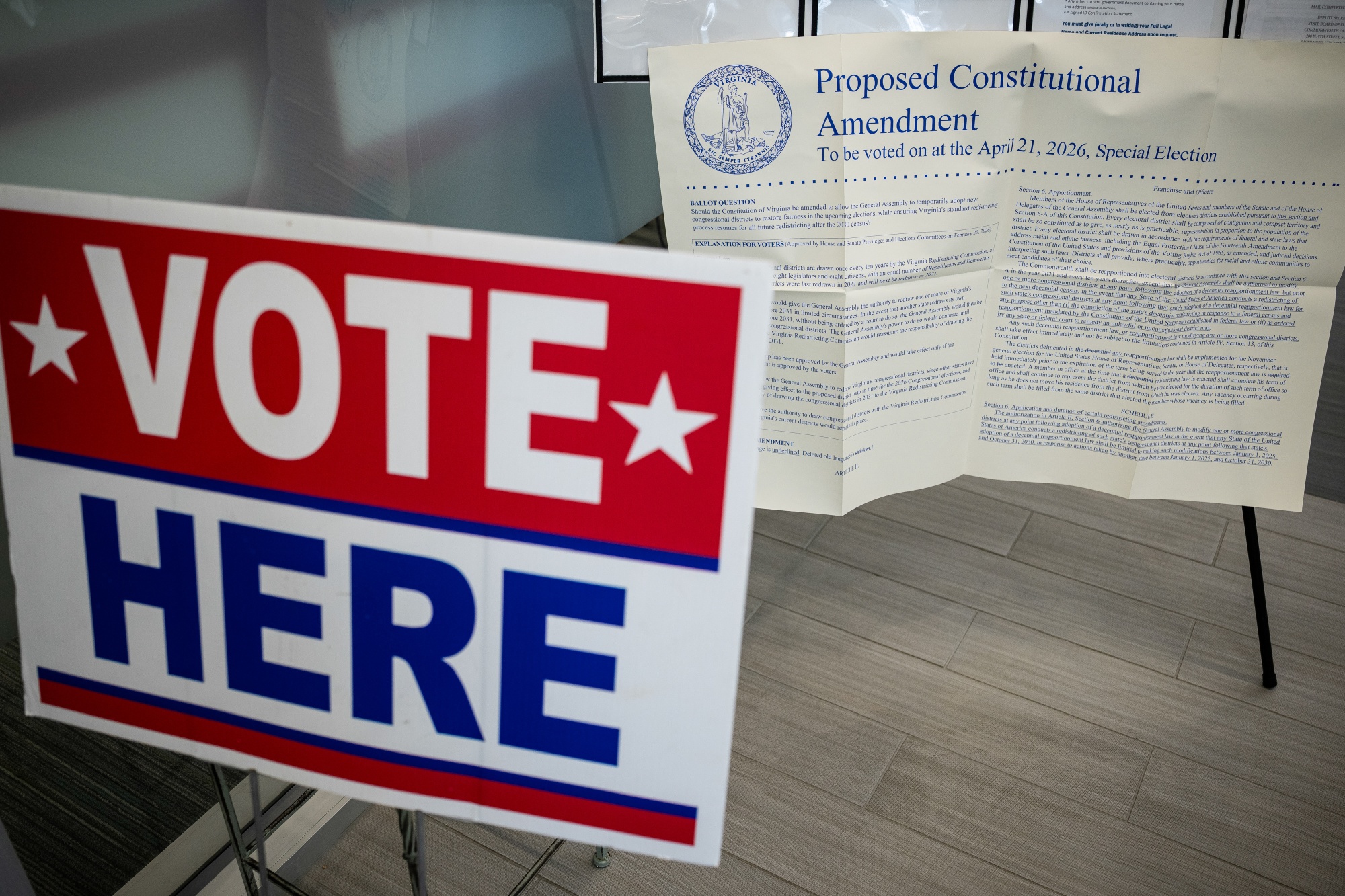 "Vote Here" signage near a printout of the proposed constitutional amendment to allow redistricting at a polling location inside Falls Church City Hall during early voting on a proposed constitutional amendment in Falls Church, Virginia, US, on Friday, March 20, 2026. Virginia lawmakers are looking to redraw the state's congressional maps, the latest push by Democrats as the party seeks to counter similar moves by Republicans in the race to win a House majority in the 2026 midterms. Photographer: Graeme Sloan/Bloomberg
