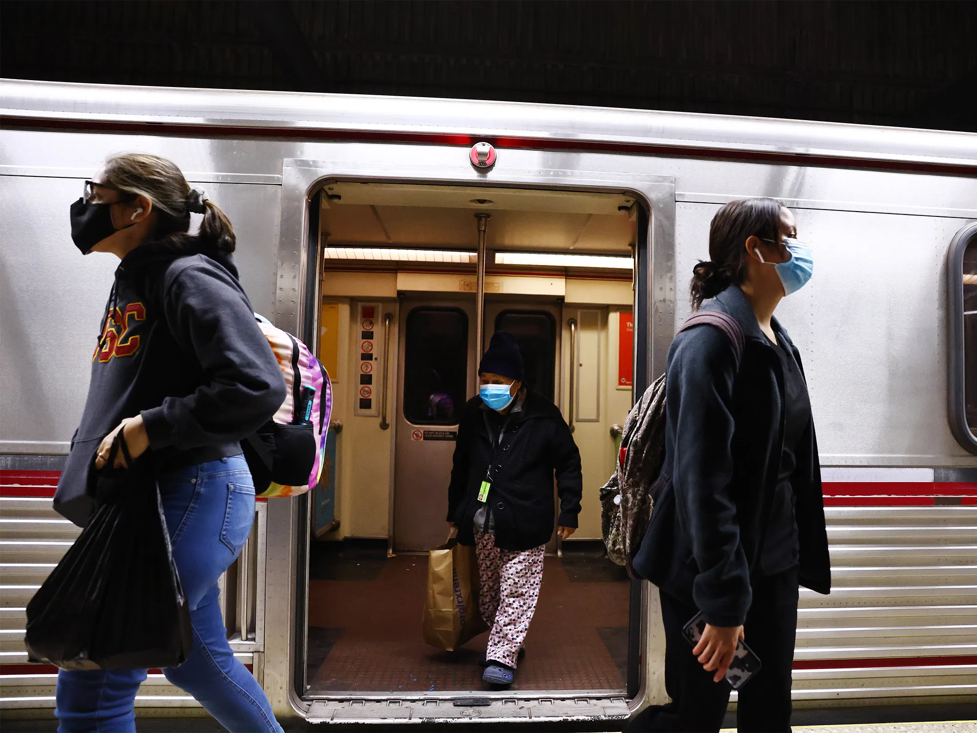 Commuters wear face coverings while departing a Los Angeles Metro Rail train in Los Angeles.