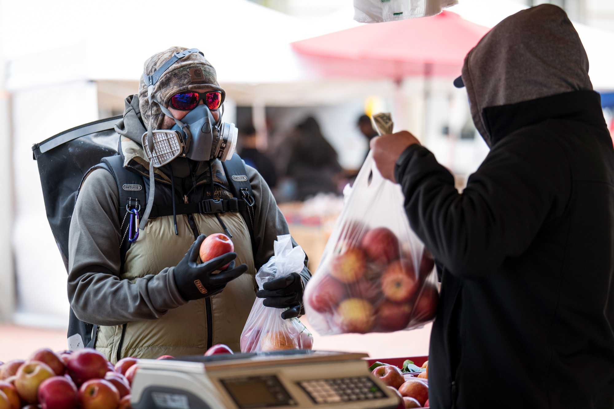 A customer buys apples at a farmers’ market in San Francisco on March 25.