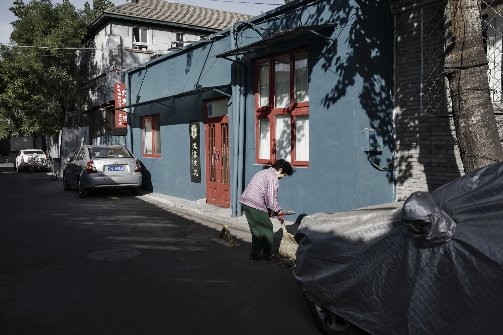 A woman sweeps a street in a traditional hutong neighborhood in Beijing, China, on Sunday, May 14, 2017. China’s economy is staging a comeback as quickening inflation boosts factory profits, while stricter capital controls and a stabilizing currency help stem outflows.