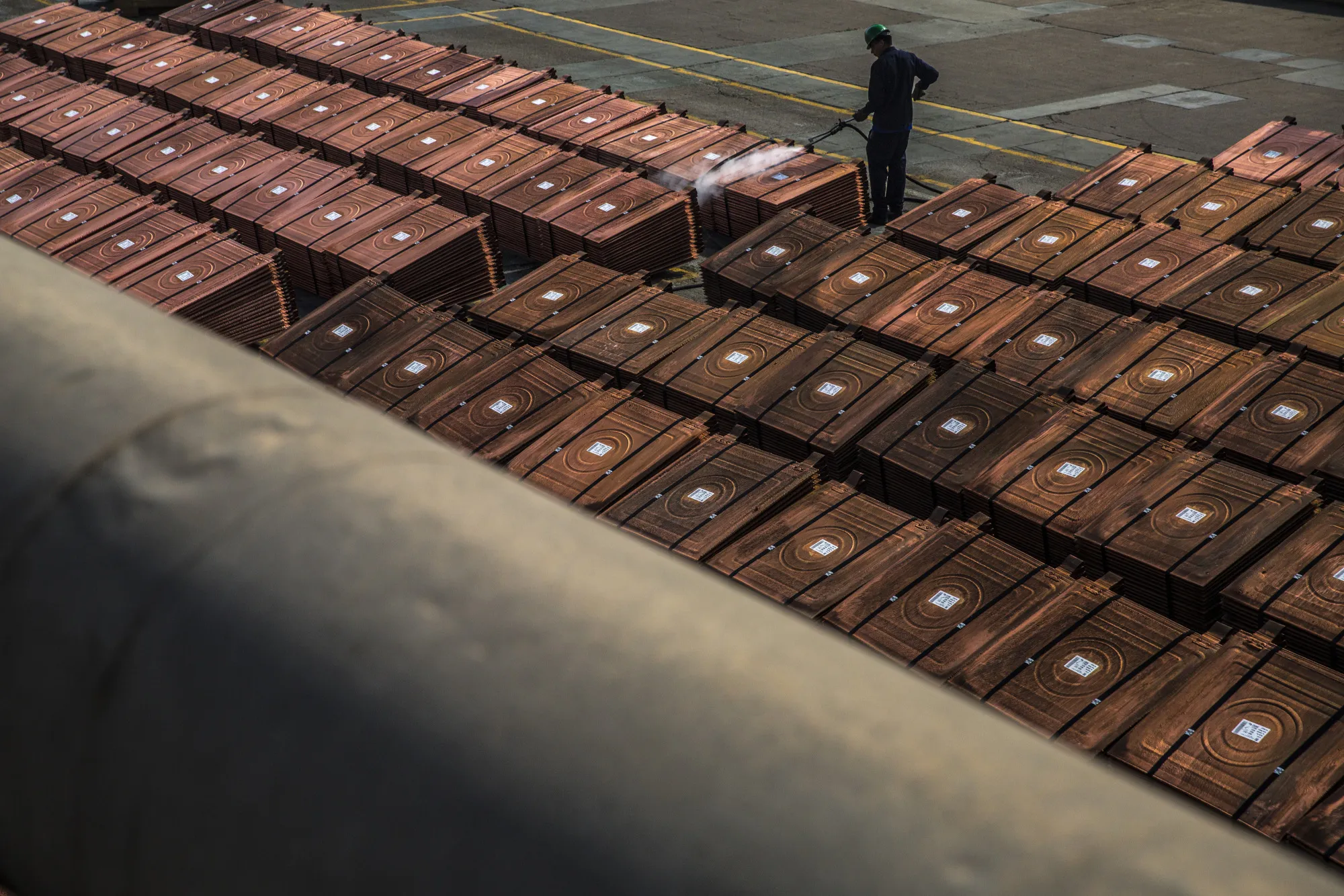 An employee sprays a pile of copper plates&nbsp;in Ilo, Peru.&nbsp;