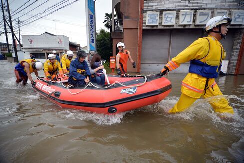 Rescue workers transport evacuees through floodwaters at Oyama in Tochigi prefecture, north of Tokyo on Sept. 10, 2015.