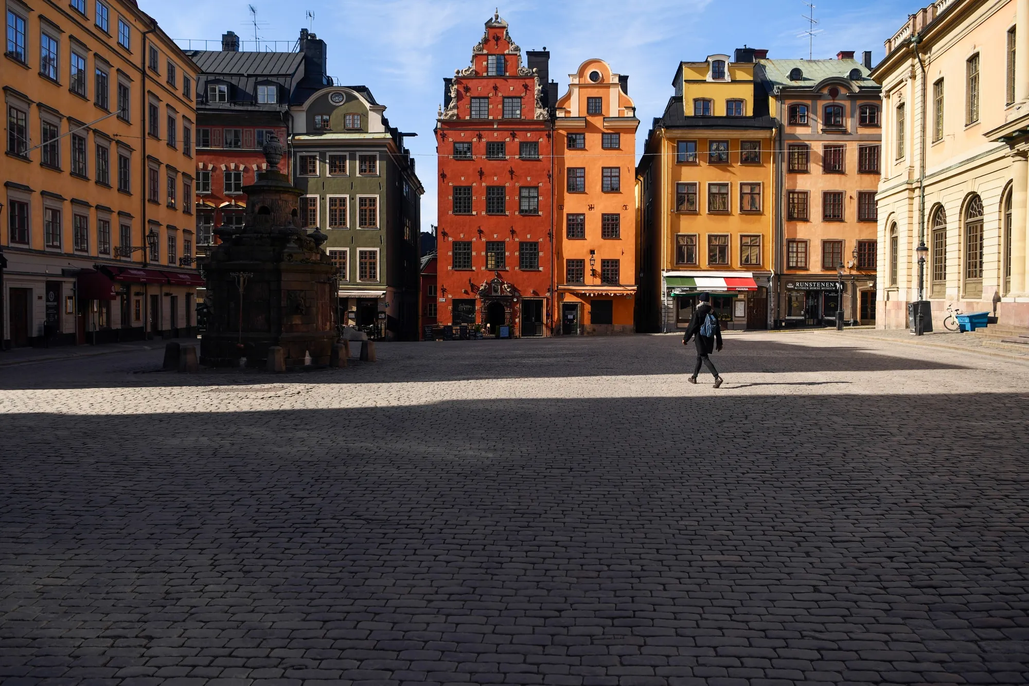A pedestrian walks through an empty Gamla Stan square in Stockholm on March 26.
