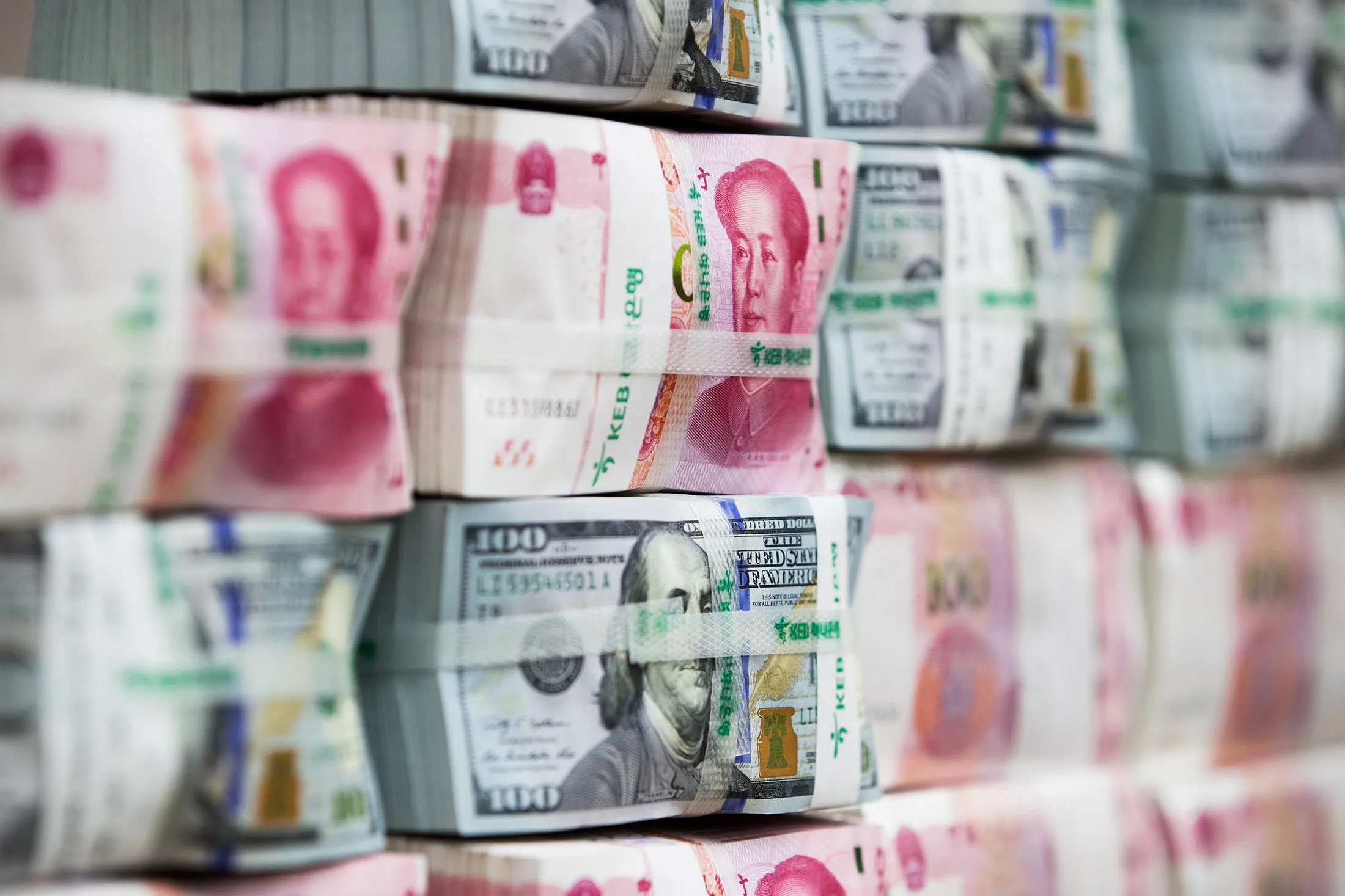 Genuine bundles of Chinese one-hundred yuan banknotes and U.S. one-hundred dollar banknotes
