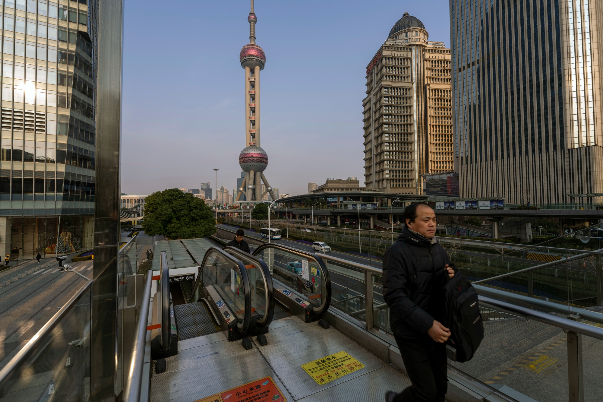Pedestrians in front of buildings in the Lujiazui financial district in Shanghai, China, on Tuesday, Jan. 6, 2026. Chinese stocks climbed to multi-year highs as persistent AI-driven gains and growing signs of an economic recovery kept sentiment upbeat. Photographer: Raul Ariano/Bloomberg