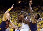 Golden State Warriors forward Draymond Green, center, is guarded by Cleveland Cavaliers guard Mike Miller (18) and guard J.R. Smith during the second half of Game 2 of basketball's NBA Finals in Oakland, Calif., on June 7, 2015.

