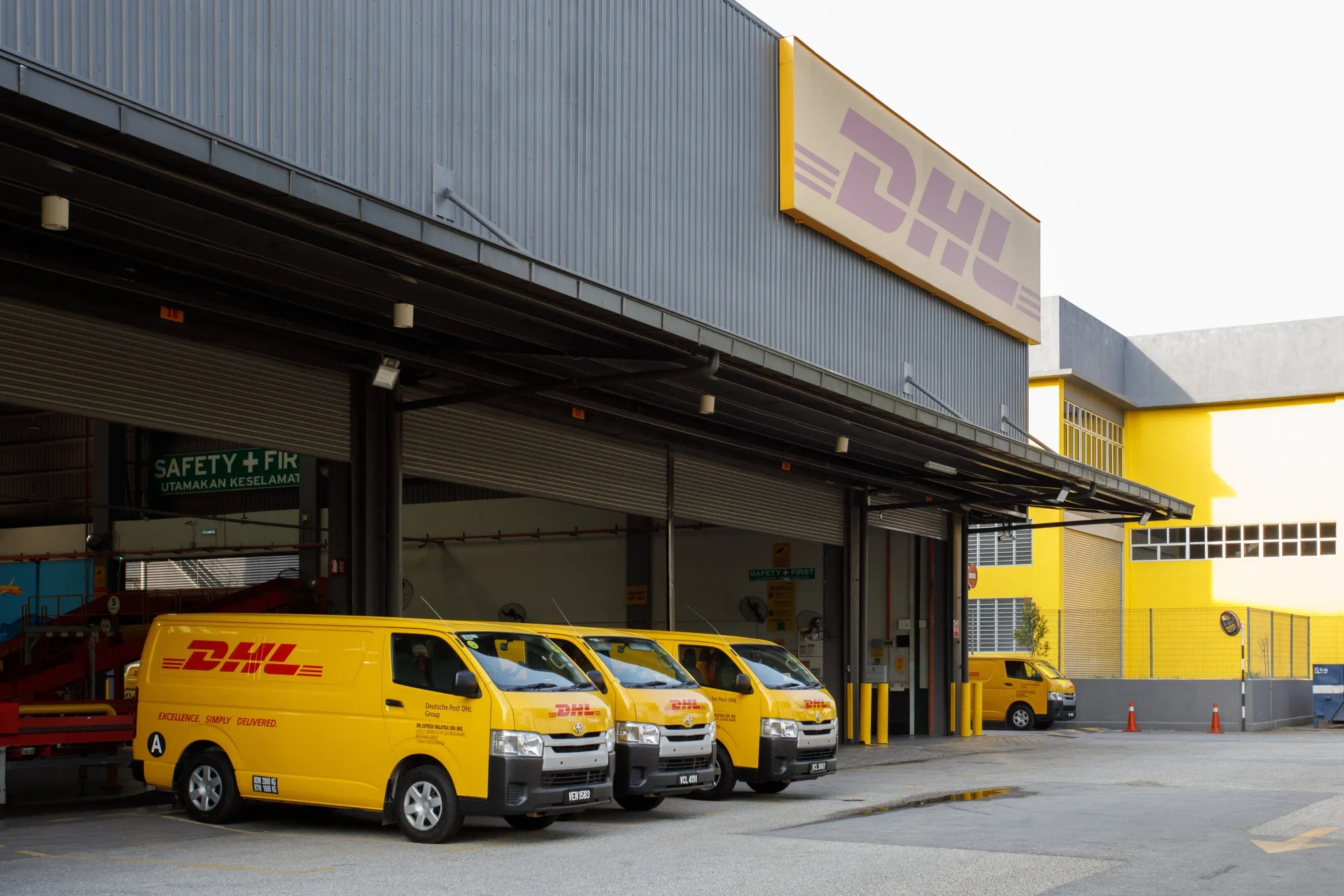 Delivery vans at a DHL Express Service Center facility.