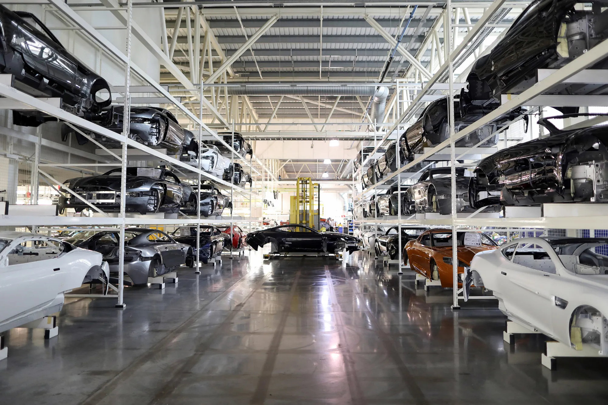 The painted bodywork of an Aston Martin DB11 luxury automobile is moved by a robot through the Aston Martin Lagonda Ltd.'s manufacturing and assembly plant in Gaydon, U.K., on Tuesday, June 6, 2017. Aston Martin may consider an initial public offering as early as next year as the British maker of James Bond’s cars seeks to capitalize on the success of Ferrari NV’s listing to lure investors, people familiar with the matter said.
