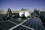Climate scientist Svitlana Krakovska stands beside the solar system she installed on the roof of her building in Kyiv.