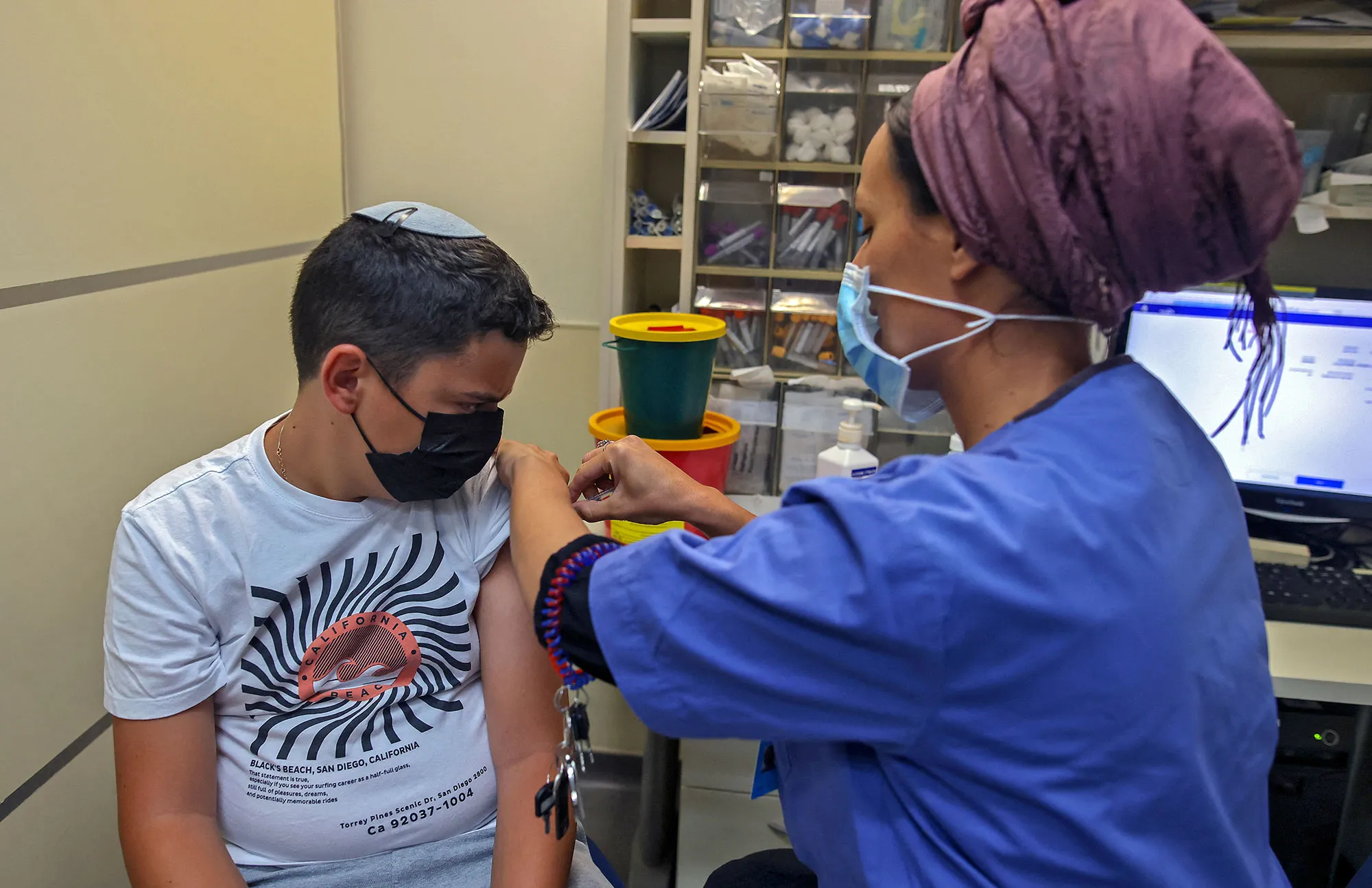 A&nbsp;health worker administers a dose of the Pfizer-BioNtech&nbsp;vaccine on a 12-year-old boy&nbsp;in Jerusalem.