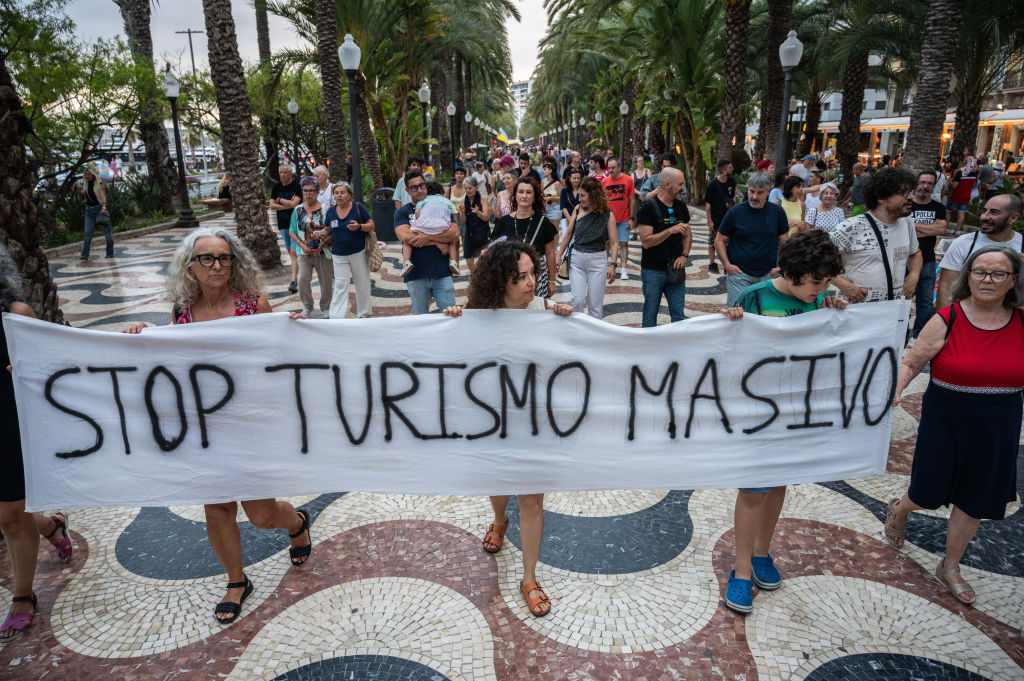 People carrying a banner reading &quot;Stop mass tourism&quot;