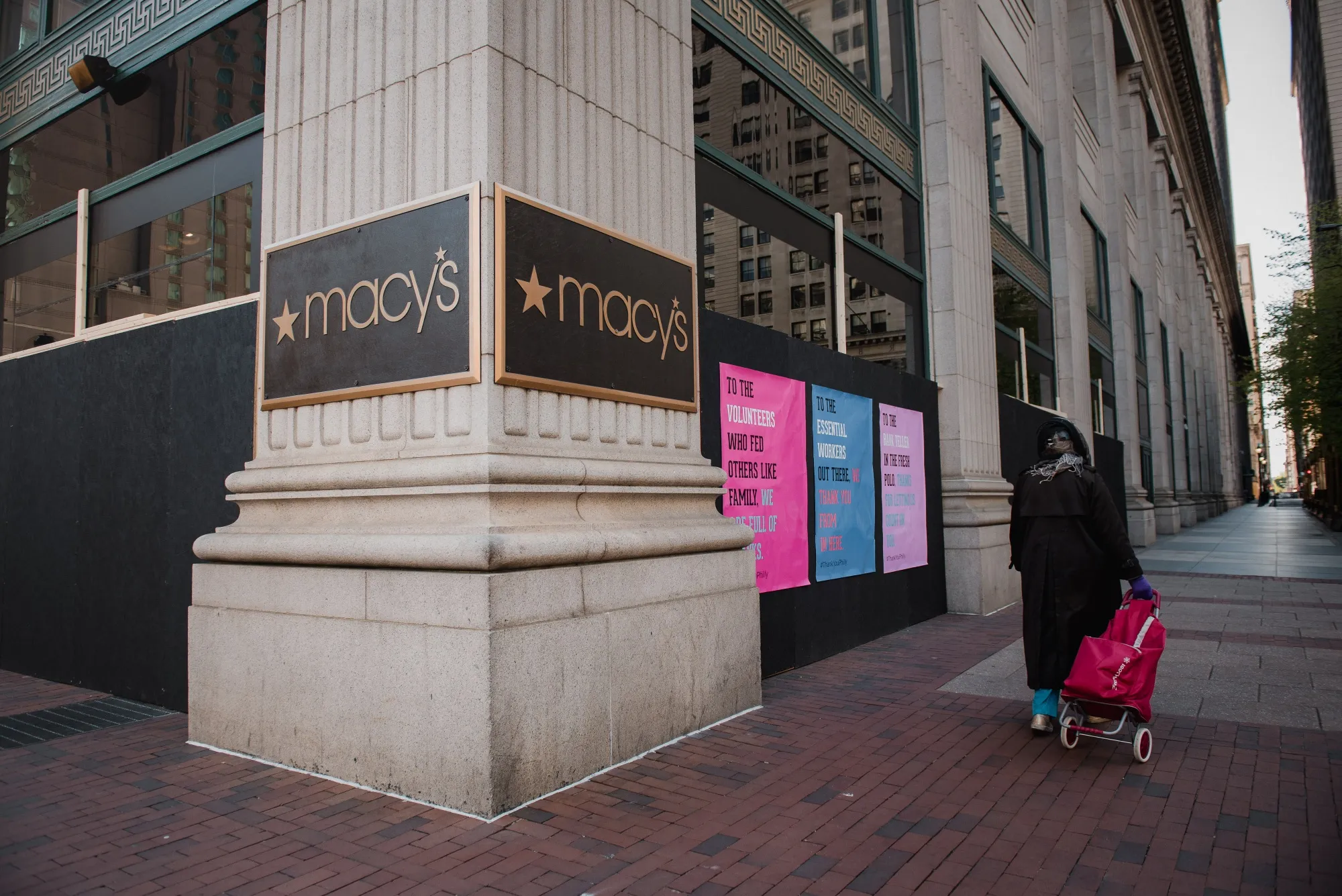 A pedestrian passes a closed Macy's store on April 15.