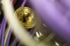 A bitcoin sits among Ethernet cables inside a communications room at an office in London, U.K..
