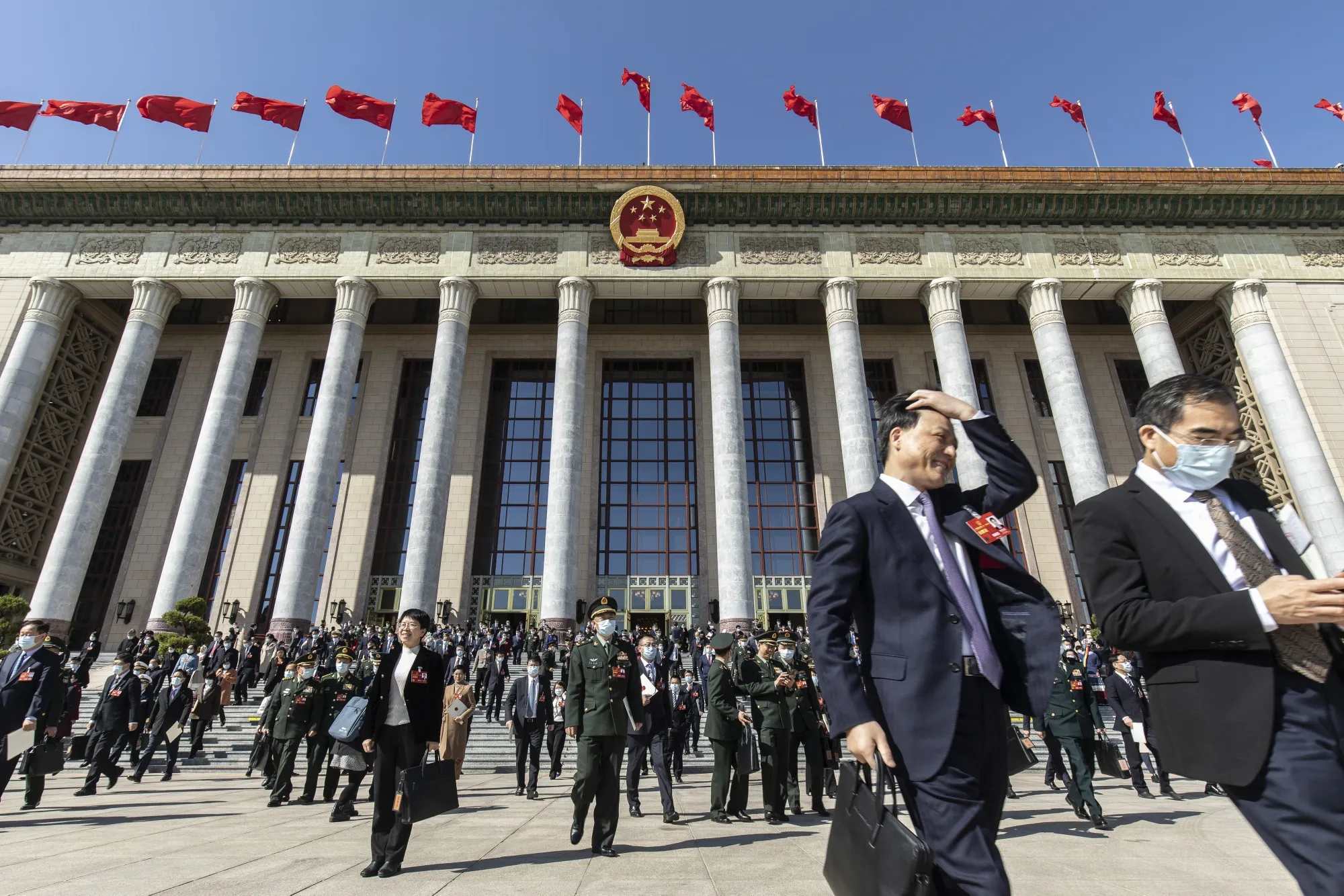 Delegates exit the Great Hall of People after attending the fifth plenary session of the First Session of the 14th National People's Congress (NPC) in Beijing, China, on Sunday, March 12, 2023.