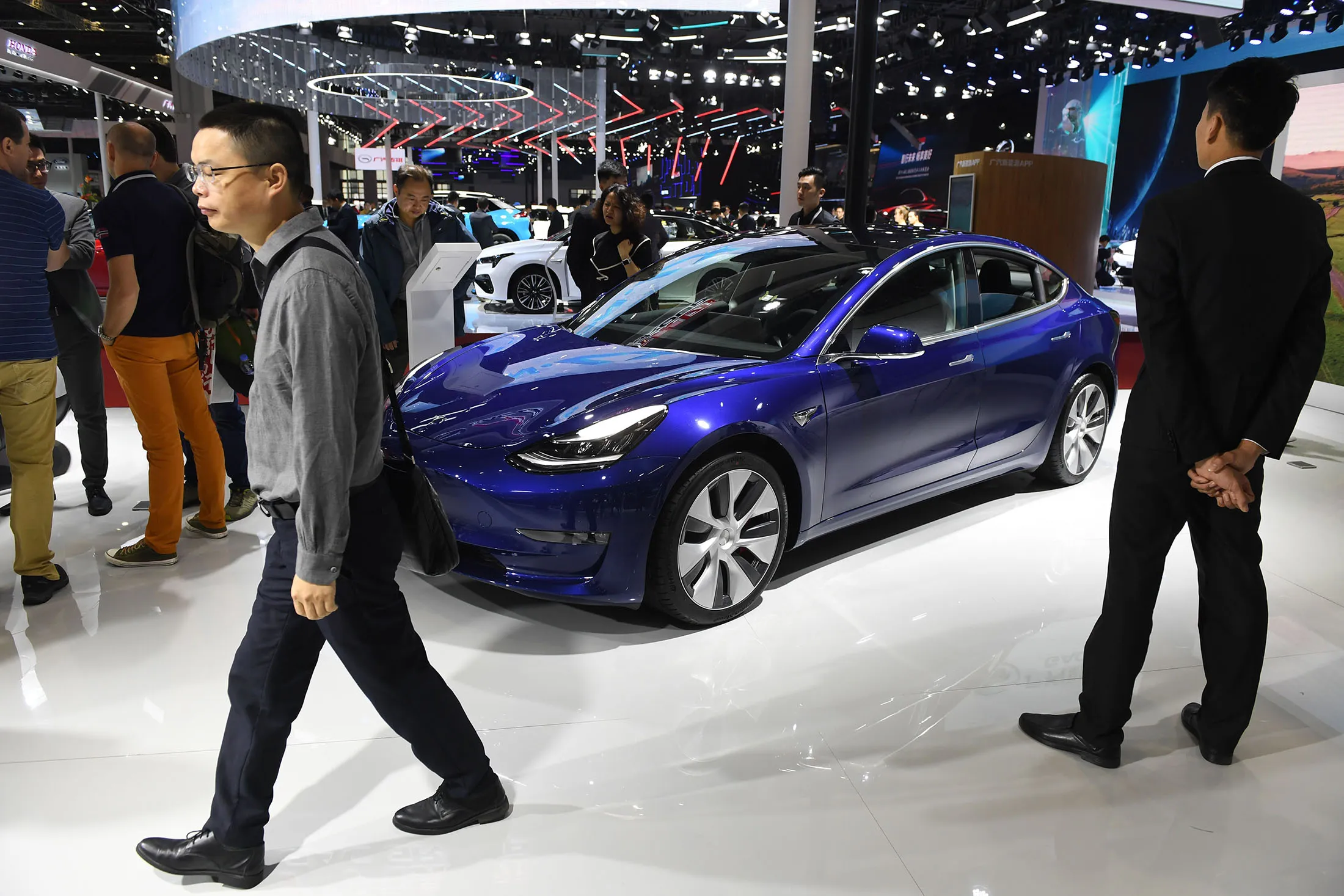 Visitors walk past a Tesla Model 3 at the Shanghai Auto Show in April&nbsp;2019.