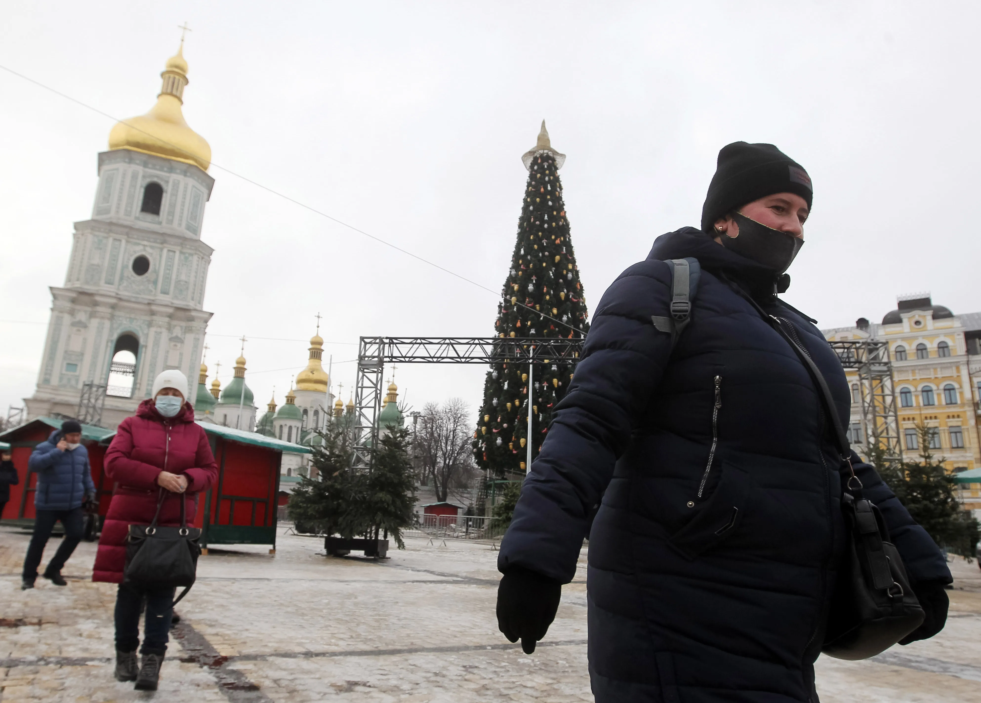 People wearing protective masks walk through Sophia Square in Kyiv last week.