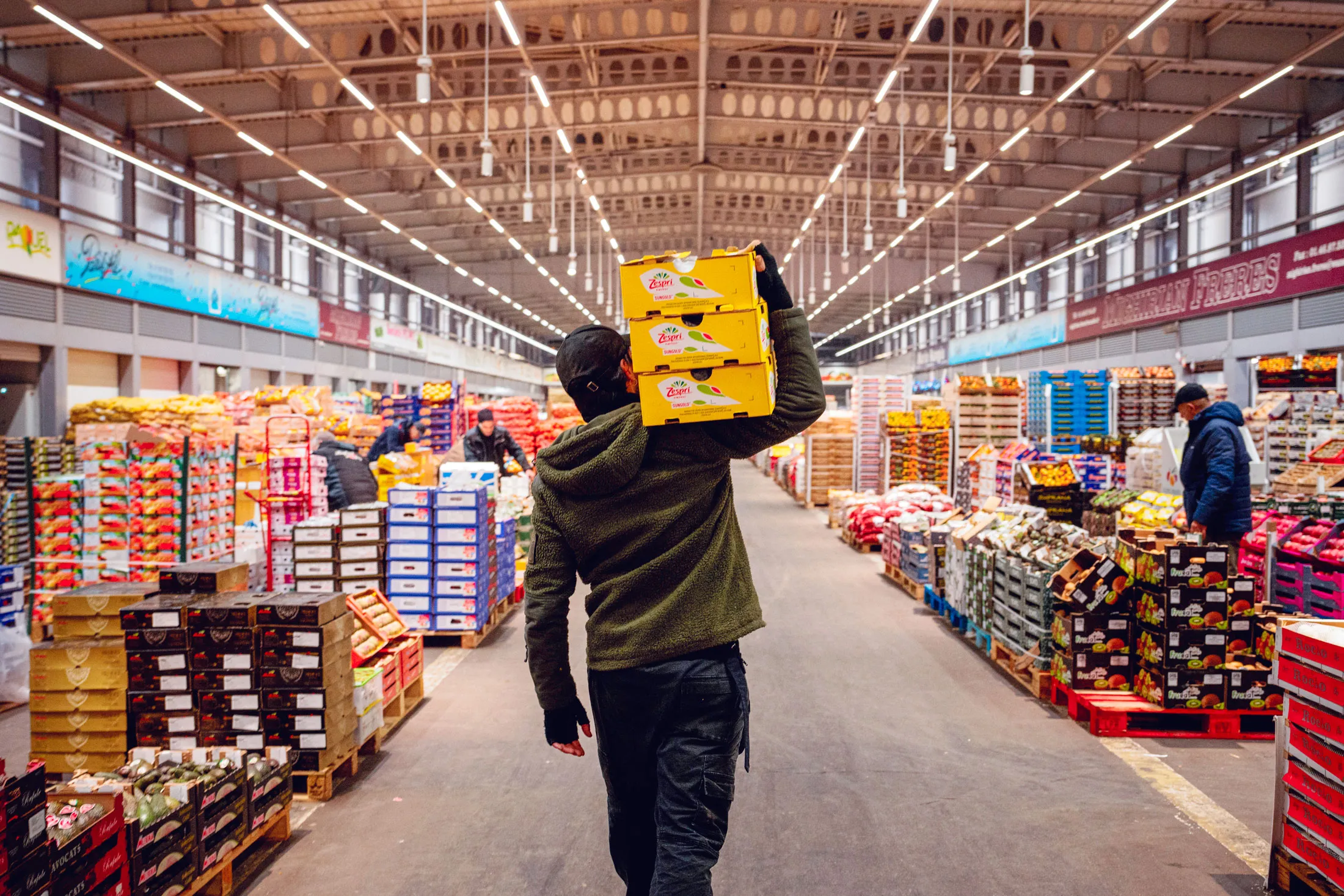 A greengrocer carries boxes of fruit and vegetables at the Rungis wholesale market near Paris.