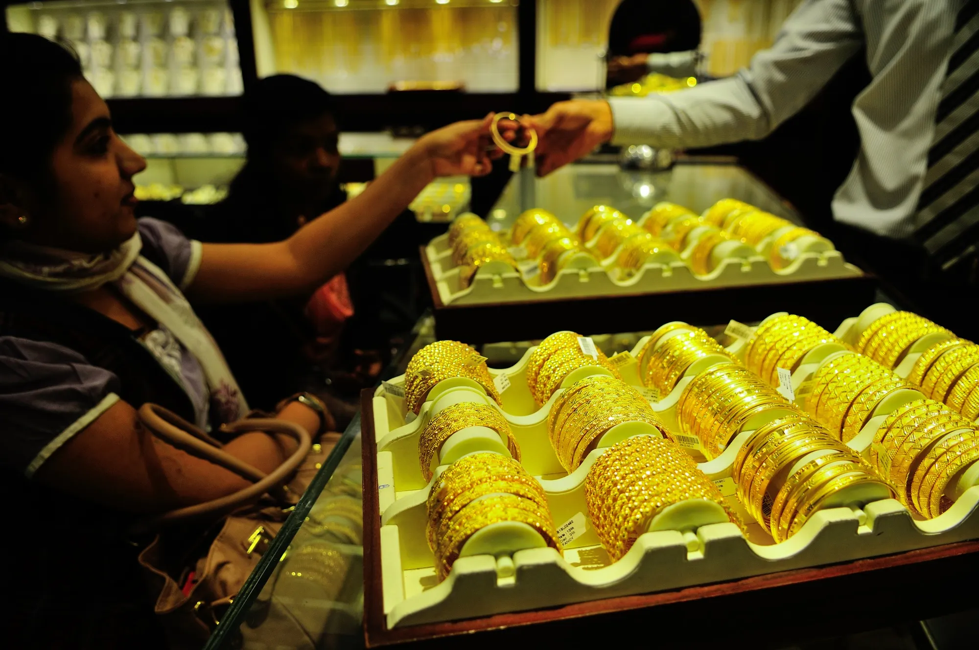 Một người phụ nữ đang xem các mẫu vòng tay vàng tại cửa hàng trang sức Joy Alukkas ở New Delhi.