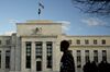 A pedestrian walks past the Marriner S. Eccles Federal Reserve building in Washington, D.C., U.S..