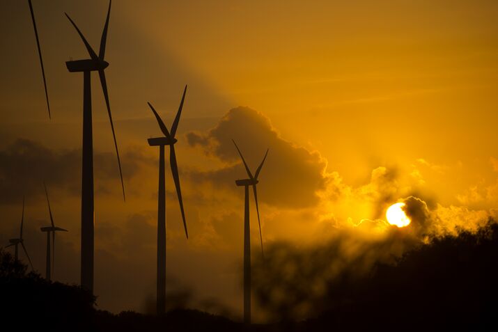 Wind turbines stand during sunset