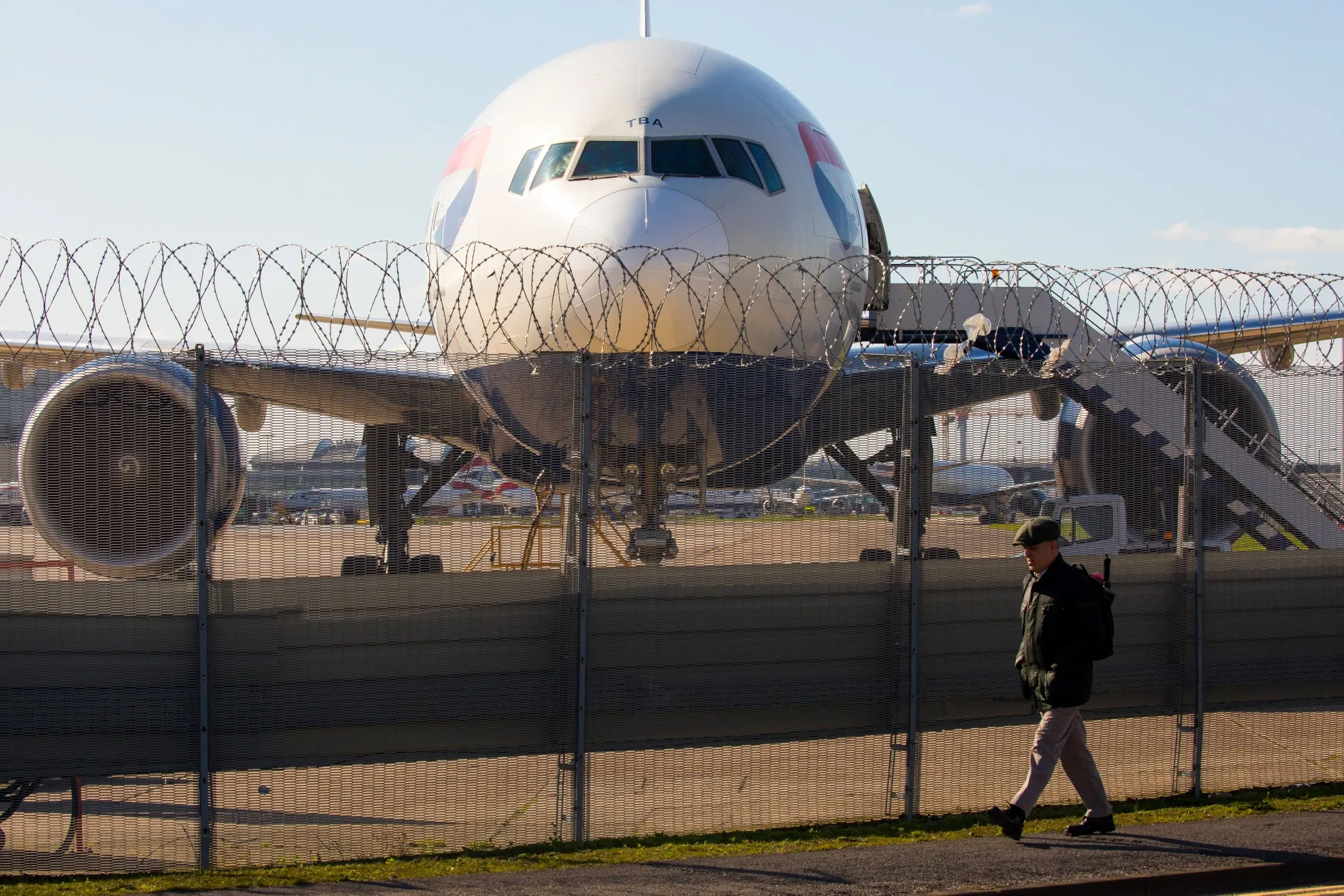 A pedestrian passes a passenger aircraft&nbsp;at London Heathrow Airport, London, U.K. on&nbsp;March 16.&nbsp;