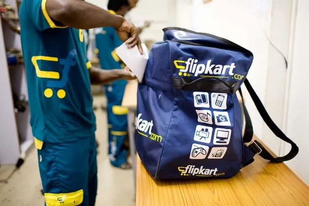 A courier for Flipkart finishes loading his backpack as he prepares to deliver packages at a distribution hub in Bangalore