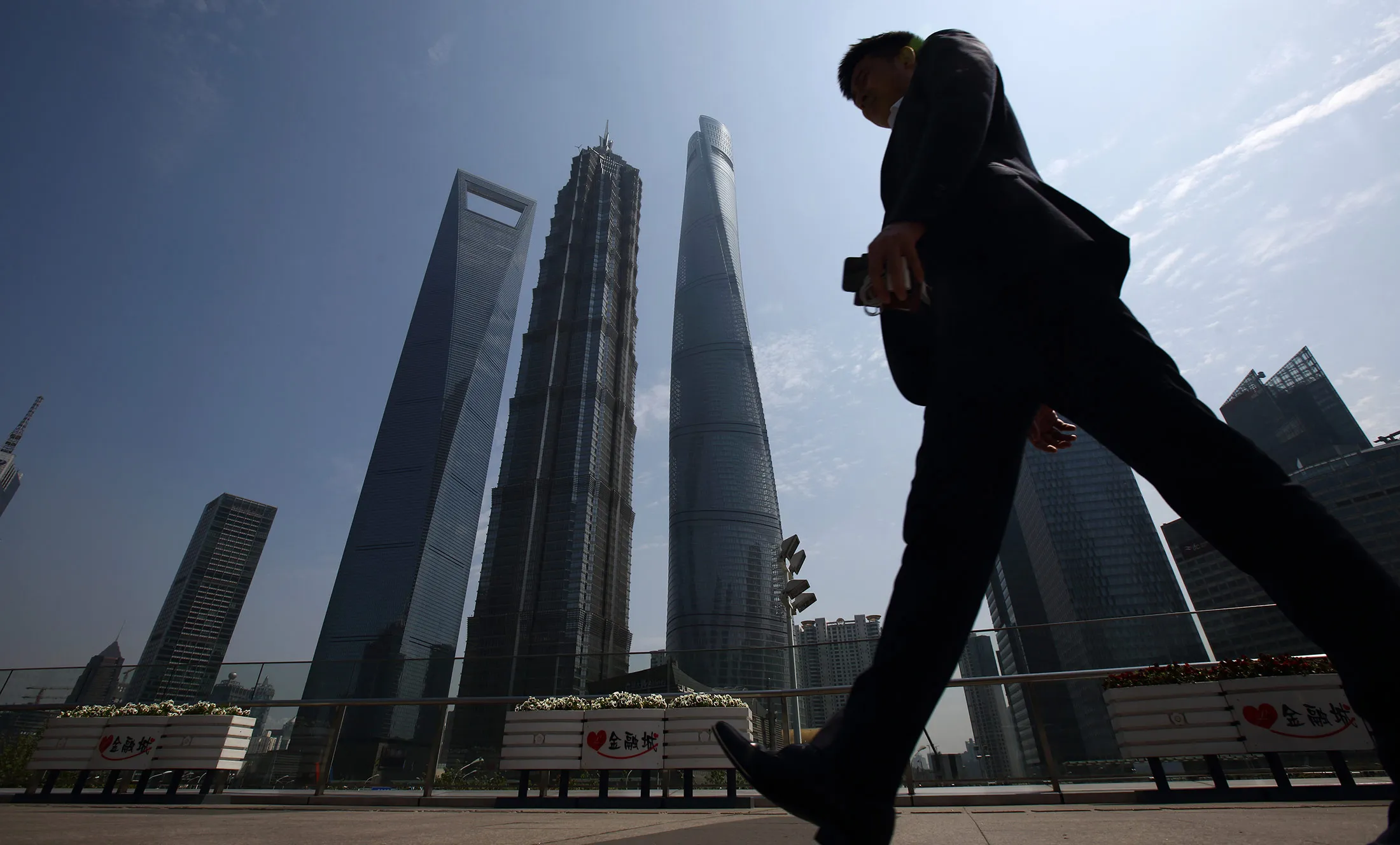 A man walks past the Shanghai World Financial Center in Shanghai.
