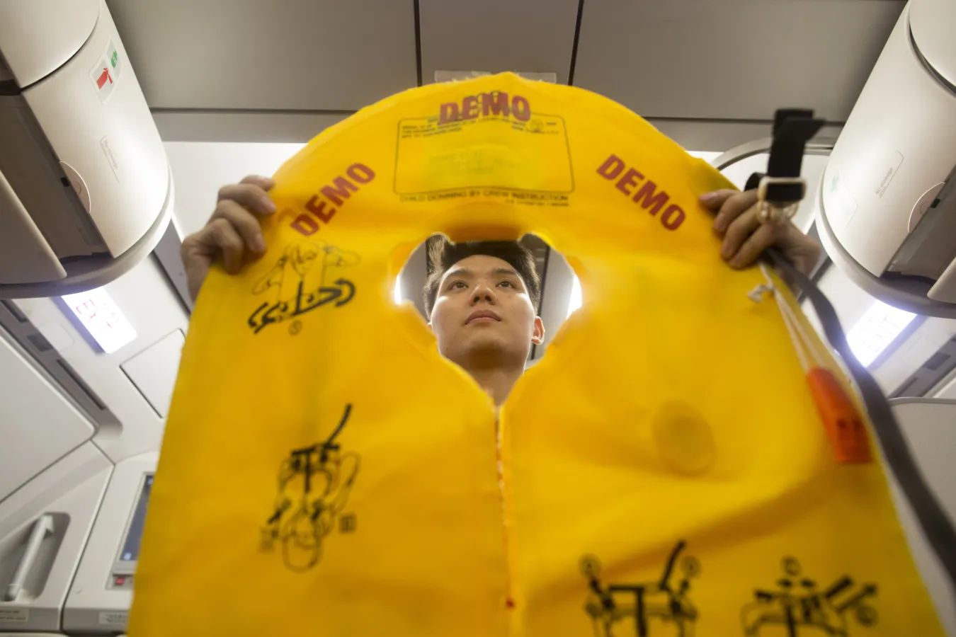A flight attendant holds an inflatable life vest during a safety presentation on board a VietJet Air aircraft, operated by VietJet Aviation Joint Stock Co., at Noi Bai International Airport in Hanoi, Vietnam. Photographer: Brent Lewin/Bloomberg
