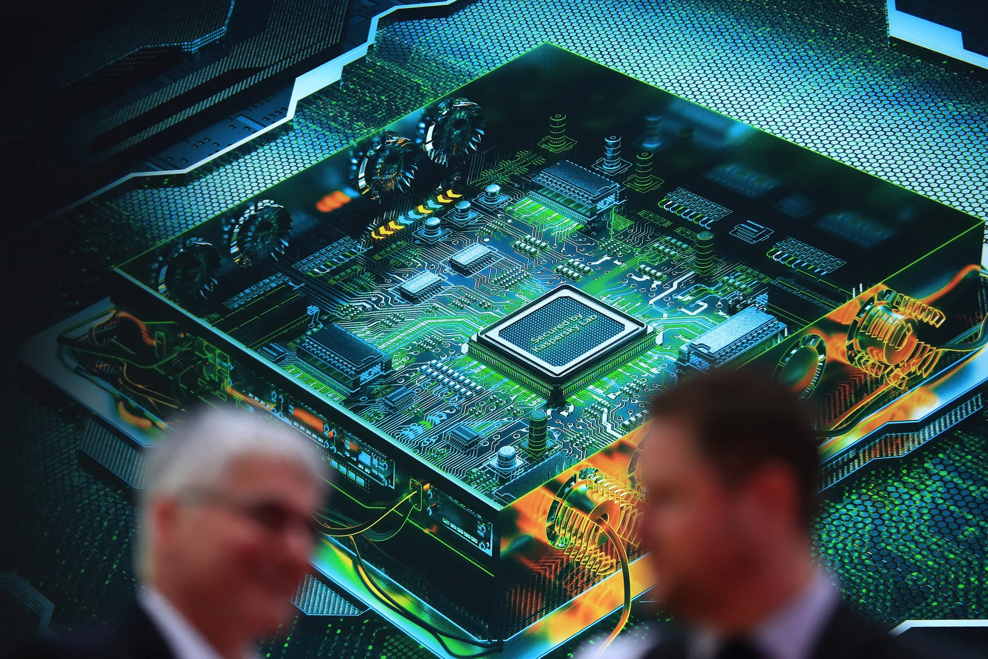 Visitors stand near a large graphic of a computer chip motherboard at the Kaspersky Lab pavilion at the CeBIT 2017 tech fair in Hannover, Germany, on Tuesday, March 21, 2017. Leading edge technologies in the digital world are showcased in this annual event which runs March 20 - 24.