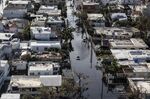 A vehicle drives through streets filled with floodwater near destroyed homes from Hurricane Maria in&nbsp;Barrio Obrero in San Juan, Puerto Rico, on Sept. 25, 2017.